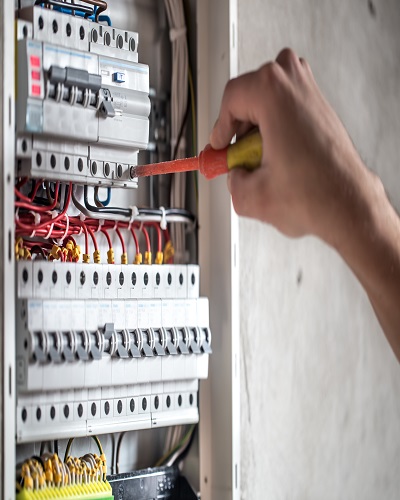 Man, an electrical technician working in a switchboard with fuses. Installation and connection of electrical equipment. Professional with tools in hand. concept of complex work, space for text. SSUCv3H4sIAAAAAAAEAI1Ry27DIBC8V+o/WJxjyS44dfoHPVTqPephgW2MQiDi0SqK8u8FEypOVW/szDK7s3N9fOg6wsErQV66a65SrbSOPjgIypoED5s77tBIdC2CUgXrFOgW5BDEYuCECTRR6wzfVpL4ACF69HnYHRIQ8JA0CvgrUTbal7qrxEqmH4ki72jPGsmmYXzkmXlTXqDWYNBGTyp/2/wh9mpktpyd/F+wPD6qbzigEZfVWmPZoUYolvellRy/A7pTewSIUtnG/5cVoHMDbZTOTgllDs03G5Y1j/pN2GiCyyuQaoNoa8/AdQ7jM2lixRfwPrXLijeDRDqFPTVzjA2rgbsqkSmzXI70aZwZm9g4Pm/pPLCB1JytOCrZWizRLypR7tLgKm9AKBspbjnrd9M09IzKqd9tJeufZ05nKjgIBunwtx9tVYW8sQIAAA==